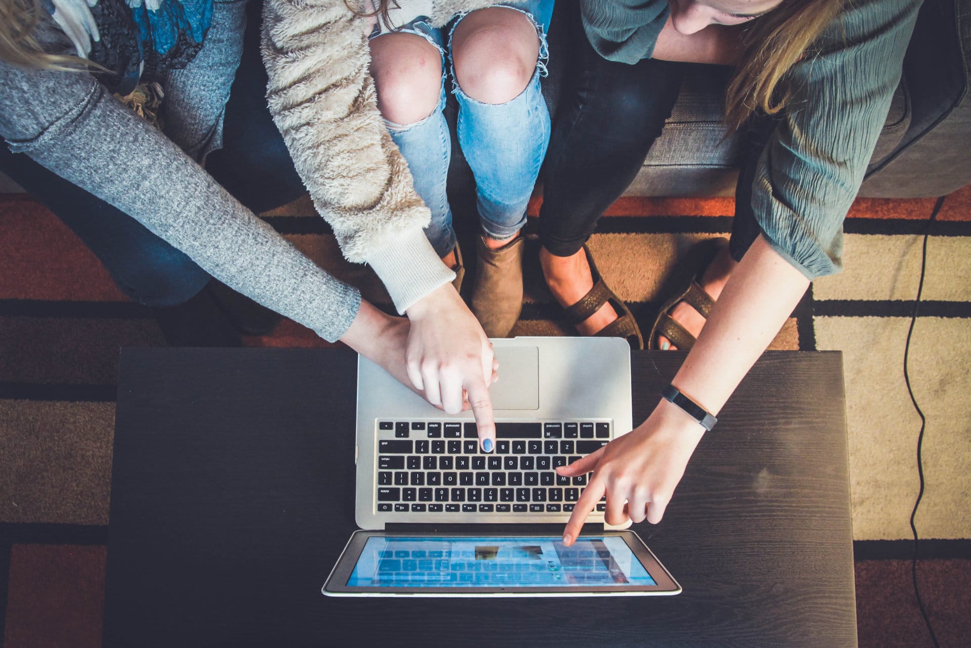 Three women examining a website on a laptop computer